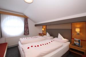 Un dormitorio con una gran cama blanca con corazones rojos. en Bella Vista Active Apart, en Nauders