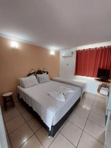 1 dormitorio con 1 cama blanca grande con cortina roja en diRoma Fiori 160 Conforto e muita diversão en Caldas Novas
