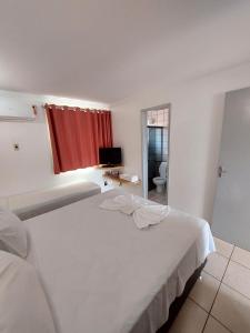 カルダス・ノバスにあるdiRoma Fiori 160 Conforto e muita diversãoのベッドルーム1室(赤いカーテン付きの白いベッド1台付)