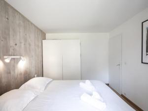 um quarto com uma cama branca e 2 almofadas brancas em Appartement Chamonix-Mont-Blanc, 2 pièces, 4 personnes - FR-1-343-230 em Chamonix-Mont-Blanc