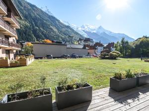 uma vista para um quintal com montanhas ao fundo em Appartement Chamonix-Mont-Blanc, 2 pièces, 4 personnes - FR-1-343-230 em Chamonix-Mont-Blanc