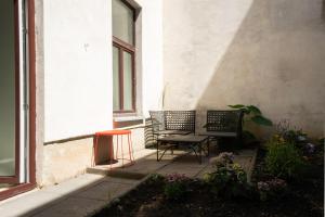 2 sillas y una mesa en un porche en Chic Newly-Renovated Apartment Steps from Subway in Vienna's Hernals District, en Viena