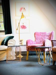 a living room with a chair and a table at Sleephotels Suite Garde in Hamburg