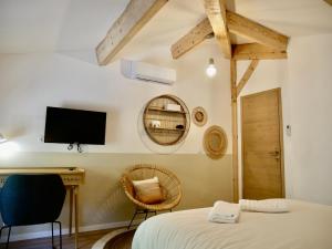 een slaapkamer met een bed en een tv aan de muur bij Callelongue-Coliving-Mas des Sous Bois in Ventabren