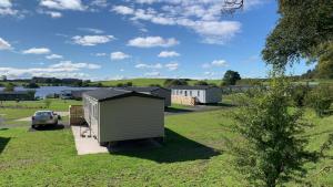 a view of a caravan park with a shed and a car at 3 Bedrooms Loch Views Heated Pool Close To Beaches in Newton Stewart
