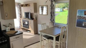 a kitchen and dining room with a table and chairs at 3 Bedrooms Loch Views Heated Pool Close To Beaches in Newton Stewart