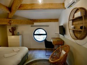 Callelongue-Coliving-Mas des Sous Bois في Ventabren: غرفة نوم بسرير ومكتب ونافذة