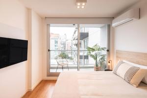 a bedroom with a bed and a large window at Top Rentals Palermo Hollywood in Buenos Aires +36 photos