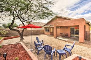 un patio con sillas y una sombrilla frente a una casa en Sunny Tucson Home Near Saguaro Natl Park!, en Avra