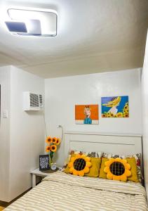 1 dormitorio con 1 cama con almohadas amarillas en Bulacan Staycation At Urban Deca Homes Marilao, en Marilao