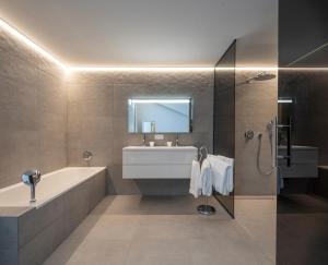 La salle de bains est pourvue d'une baignoire, d'un lavabo et d'un miroir. dans l'établissement Les Orangers by Sezz, à Saint-Tropez