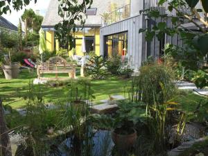 a garden with a bench and a pond at Ti Laouenek in Vannes