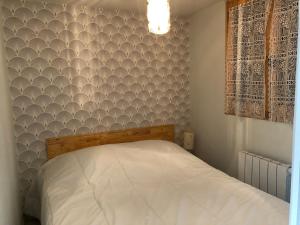 1 dormitorio con cama y pared pintada en HERMINE en Morillon