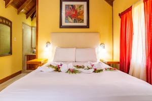 Un dormitorio con una cama blanca con flores. en Cahal Pech Village Resort en San Ignacio