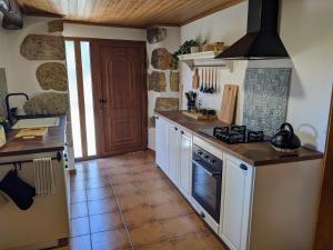 a kitchen with a counter and a stove top oven at Casa Canela apartment and pool. in Serpins