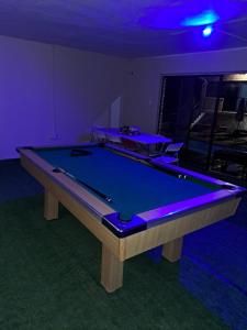 a pool table in a room with purple lighting at Hidden Inn in Pietermaritzburg