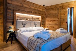 a bedroom with a bed with blue towels on it at Lo Scoiattolo Hotel in Gressoney-la-Trinité