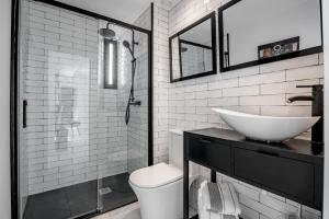 łazienka z umywalką i przeszkloną kabiną prysznicową w obiekcie Dreams of Marbella Old Town w Marbelli