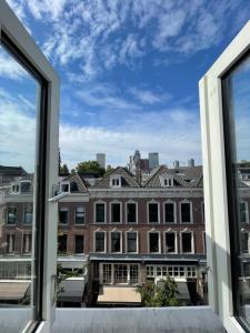 une fenêtre ouverte avec vue sur un bâtiment dans l'établissement Thuis bij Schell, à Rotterdam