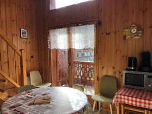 comedor con mesa, sillas y ventana en HERMINE en Morillon