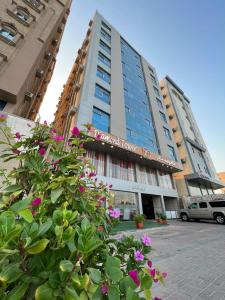 budynek z fioletowymi kwiatami przed nim w obiekcie Diamond Tower w mieście Al-Dżubajl