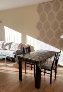 uma sala de estar com uma mesa e um sofá em Апарт Диана em Yambol