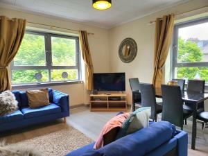 a living room with blue couches and a dining room at Business & Familes Three Bedrooms By Sensational Stay Short Lets & Serviced Accommodation, Aberdeen With Balcony & Free Parking in Aberdeen