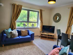 a living room with a blue couch and a tv at Business & Familes Three Bedrooms By Sensational Stay Short Lets & Serviced Accommodation, Aberdeen With Balcony & Free Parking in Aberdeen