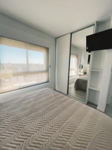1 dormitorio con espejo grande y cama en Departamento de un dormitorio - HIPÓLITO en Santa Fe