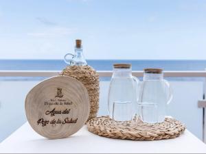 a couple of wine bottles and glasses on a table at Balneario Pozo de la Salud in Sabinosa