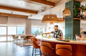 a man preparing food at a bar in a restaurant at Prima Music Hotel in Eilat