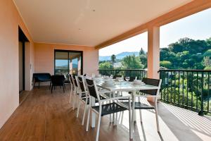 d'une salle à manger avec une table et des chaises sur un balcon. dans l'établissement Villa Terrasse et Piscine à l'entrée de Porticcio, à Cauro