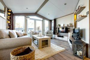 a living room with a couch and a tv at Koie Holiday Home in Stranda