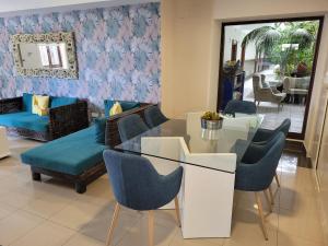 a living room with a glass table and blue chairs at Balneario Pozo de la Salud in Sabinosa