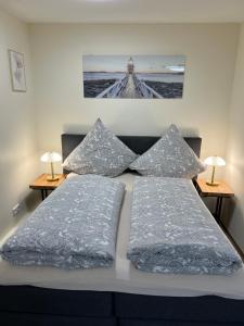 a bed with two pillows and a picture on the wall at Souterrain Studio-Apartment in Nürnberg