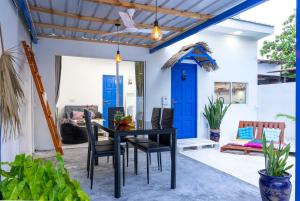 uma sala de jantar com uma mesa e cadeiras pretas e uma porta azul em Villa Boheme em Ukulhas