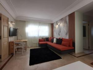 卡薩布蘭卡的住宿－Dior D'Anfa，客厅配有红色的沙发和桌子