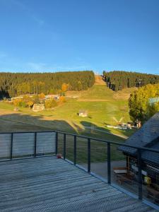 a view of a golf course from a deck at k1 sporthotel - Bike & Ski inklusive Hotel in Kurort Oberwiesenthal