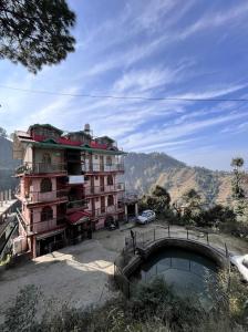 a building with a bridge in front of a mountain at YATIKA HOMESTAY in Shimla