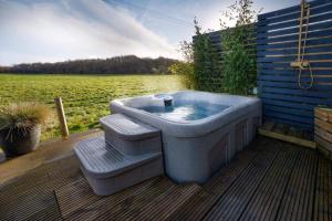 una bañera sentada en una terraza junto a un cuerpo de agua en Sol Lodge & Boutique Spa, en Kent