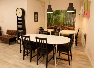 a dining room with a table and chairs and a clock at Alojamientos Cantíber in Santander