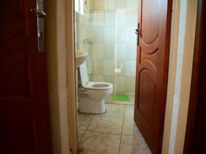 a bathroom with a toilet and a sink at Room in BB - Martin Aviator Hotel in Kigali