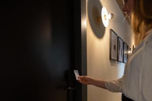 a woman is opening the door to a room at Boutique Hotel Helder I Kloeg Collection in Renesse