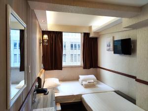 a small room with a bed and a window at Celltronik Hostel 先創旅店 in Hong Kong
