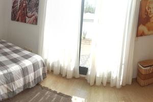 a bedroom with white curtains and a bed and a window at Ático en Paiporta con 2 grandes terrazas in Valencia