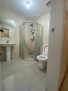 een badkamer met een douche, een toilet en een wastafel bij CedarPeak213b in Baguio