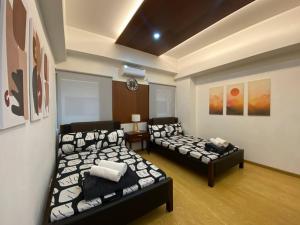 een kamer met 2 bedden en een bank. bij CedarPeak213b in Baguio