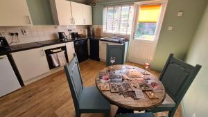 a kitchen with a wooden table and chairs in a kitchen at The Kingfisher, by Spires Accommodation a great place to stay for Drayton Manor Park and The NEC in Kingsbury