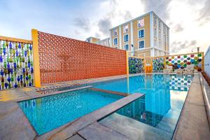 a swimming pool in front of a building at Hotel SRM Grandeurs in Tudiyalūr