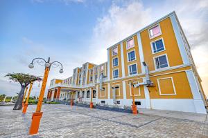 a row of buildings on a street with a street light at Hotel SRM Grandeurs in Tudiyalūr